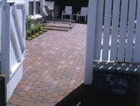 Red clay pavers and white picket fence