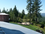 Firepit positioned on scenic overlook with lawn and natural rock landscaping