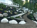 Landscaped hillside working around existing concrete retaining wall