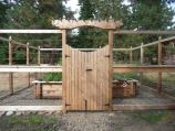 Deer-resistant fence guarding raised wooden garden boxes