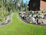 Boulder retaining wall with paver edging