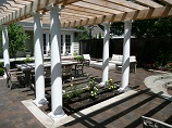 Flower bed embedded in patio with shade from custom pergola