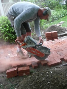 Here Nate is cutting through the clay paver using a dry hot saw.