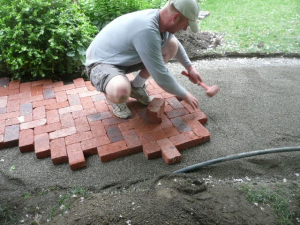 Nate laying a herringbone pattern of clay pavers.
