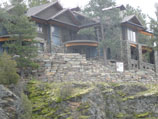 Stacked natural stone in three tier stepped retaining wall