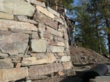 Curved, natural stacked rock retaining wall