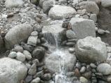 Multiple tier natural boulder waterfall with river stone