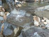 Basalt bird baths and bubbler rock incorporated into water feature