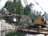 Offloading landscape construction material from a barge via crane